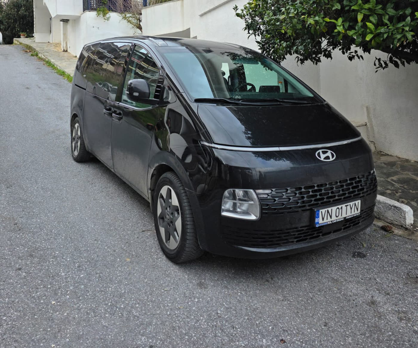 Hyundai Staria neagră cu numărul VN 01 TYN, parcată pe o stradă dintr-un sat grecesc